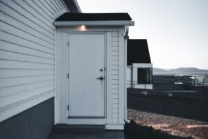 Clean residential home exterior with washed siding and trim on a sunny day